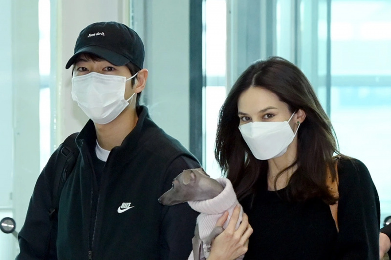 Song Joong Ki e sua esposa Katy Louise Saunders cumprimentam os fãs a caminho da Europa para as filmagens de “My Name Is Loh Kiwan”